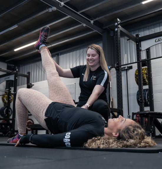 An athlete pausing mid-workout, holding their leg due to a potential injury